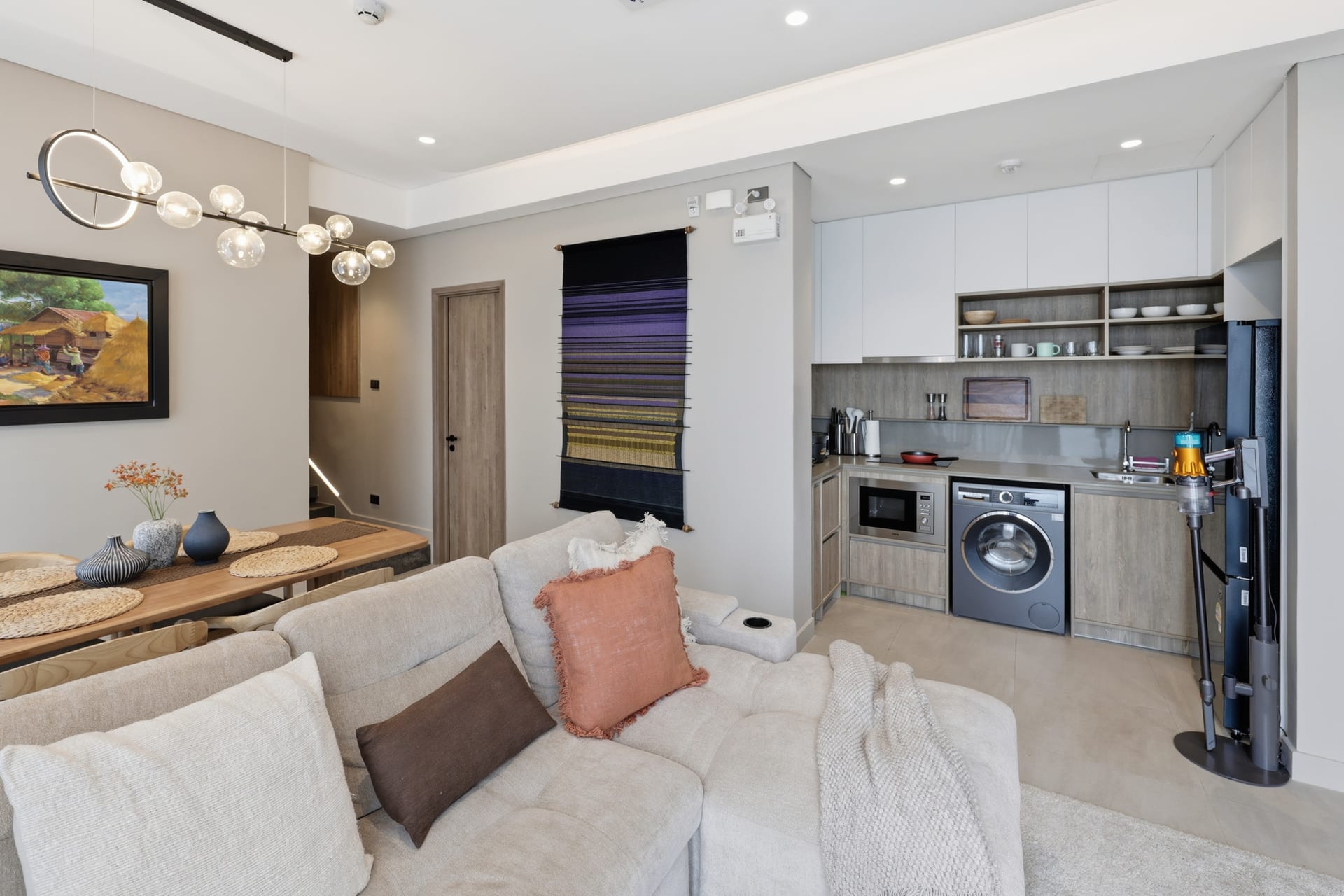 Wide view of the open-plan great room and kitchen in daylight, looking through to the sea-facing terrace