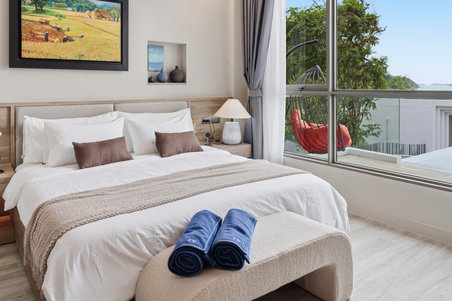 The primary bedroom in bright daylight with sliding doors to the terrace and an airy, light interior